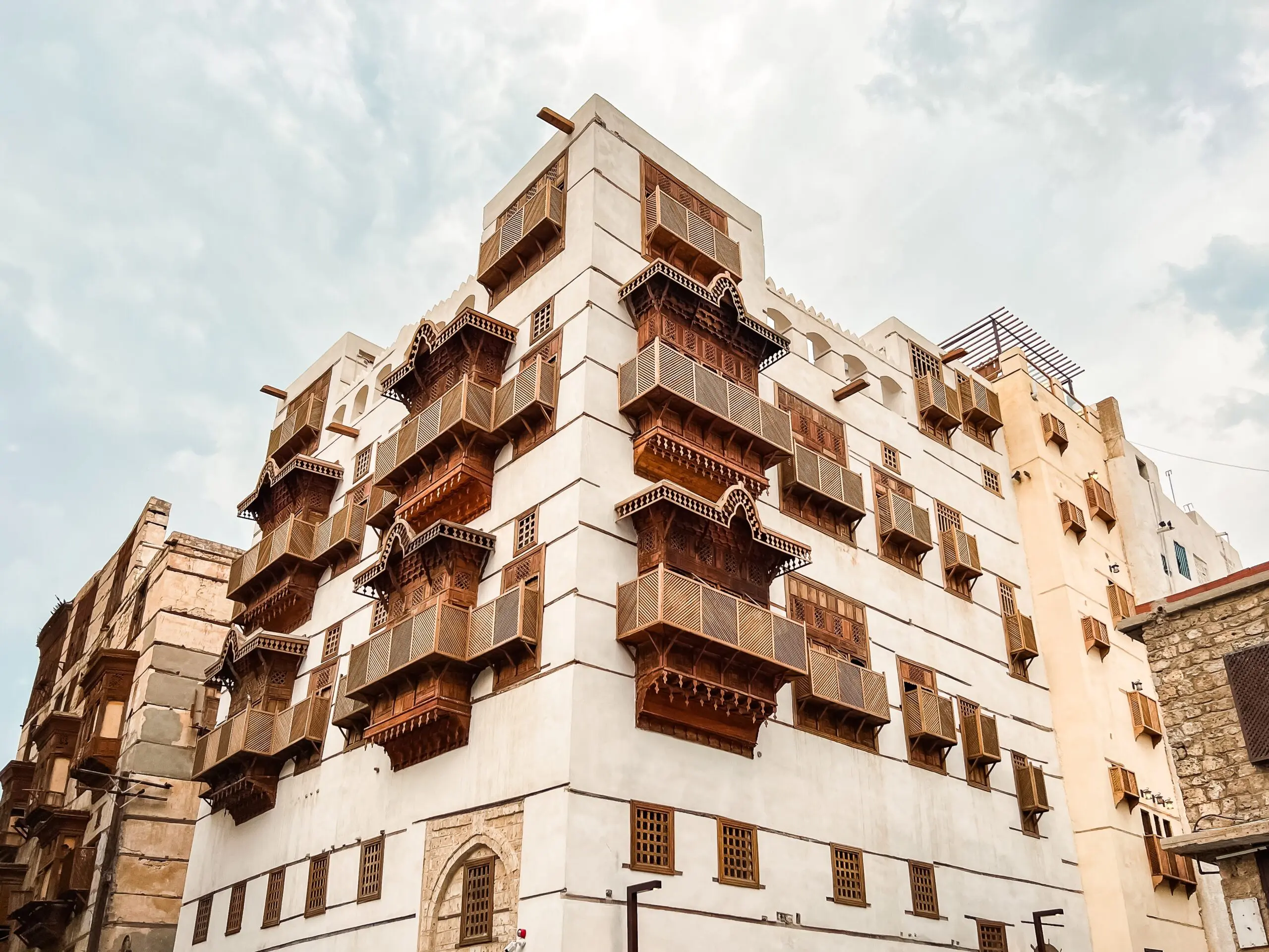 AlBalad, Jeddah's historic district, showcases traditional architecture with intricate wooden balconies and ornate doorways. Narrow, bustling streets lead past souks offering spices and textiles, while historic coral stone buildings evoke the city's rich cultural heritage