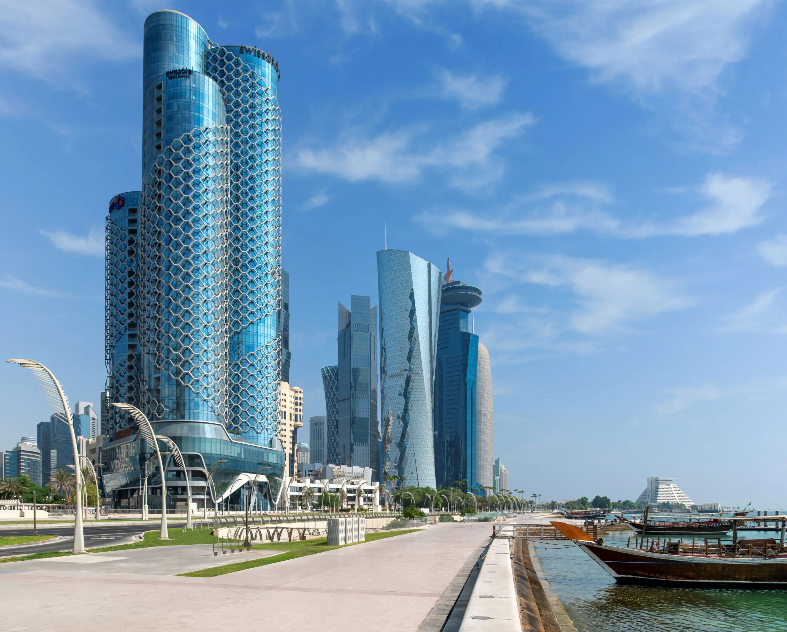 Swissôtel Corniche Park Towers Doha rising along the Doha Corniche, featuring its signature honeycomb façade with West Bay skyline in the background.