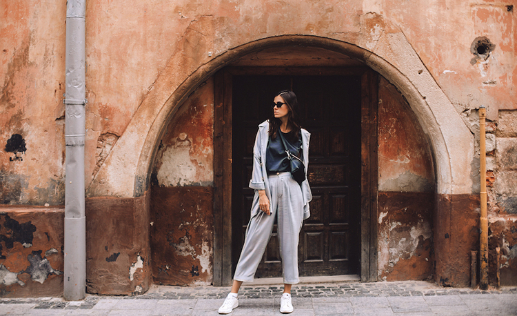 Women walking near old door. Girl dress in t-shirt, jacket and pants. Minimalist grey color look, lifestyle fashion portrait of young stylish hipster woman walking on the street, wearing trendy outfit; Shutterstock ID 1527800102; purchase_order: 23