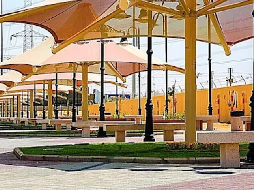 Alsafa Walkway in Jeddah featuring a shaded path with umbrellas and greenery along the walking area.